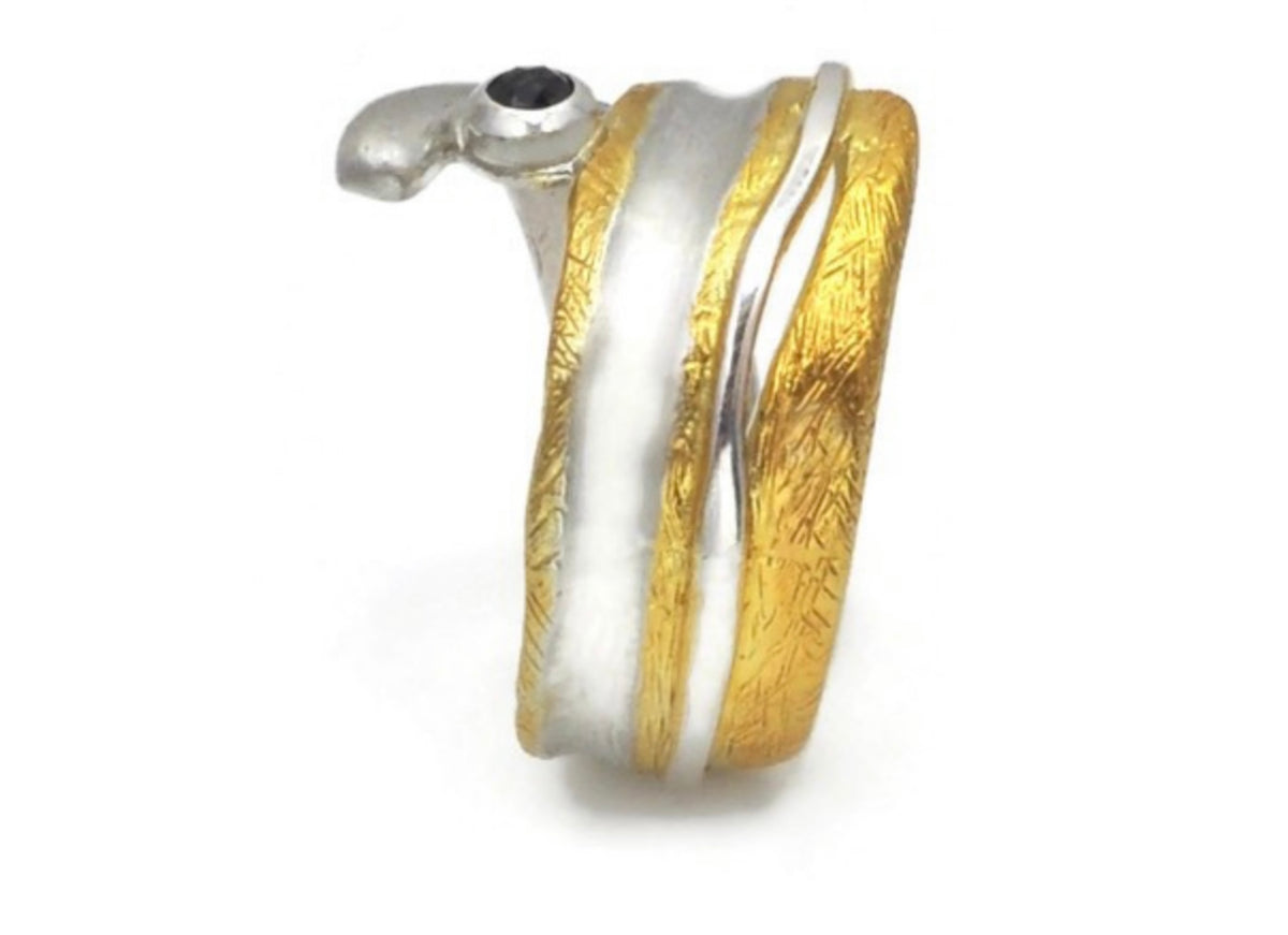 Jewelry item with gold, silver, and black elements on a white background