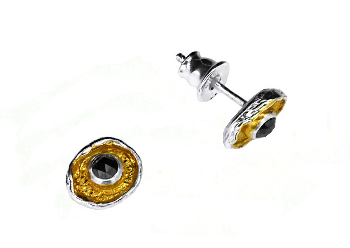 Pair of gold and silver earrings on a white background