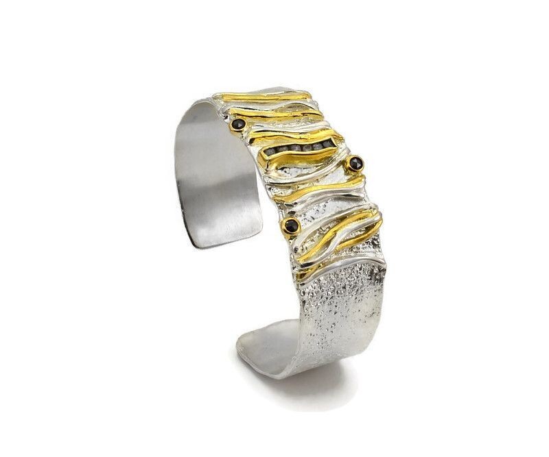 Silver and gold bracelet on a white background