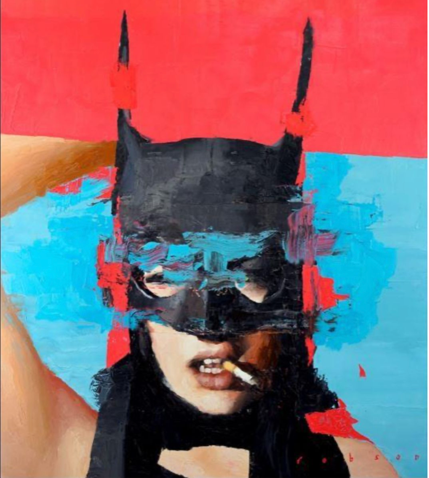 Person wearing a black mask with bat-like ears against a red and blue background