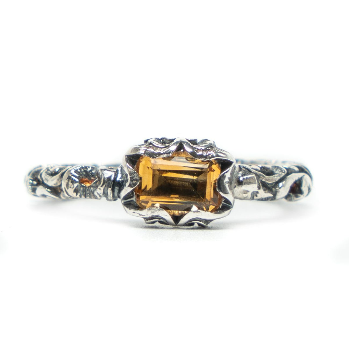 Silver ring with a rectangular gemstone on a white background