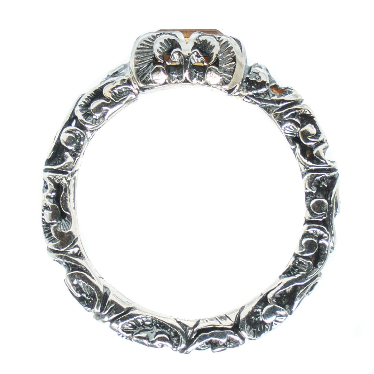 Silver ring with intricate designs on a white background