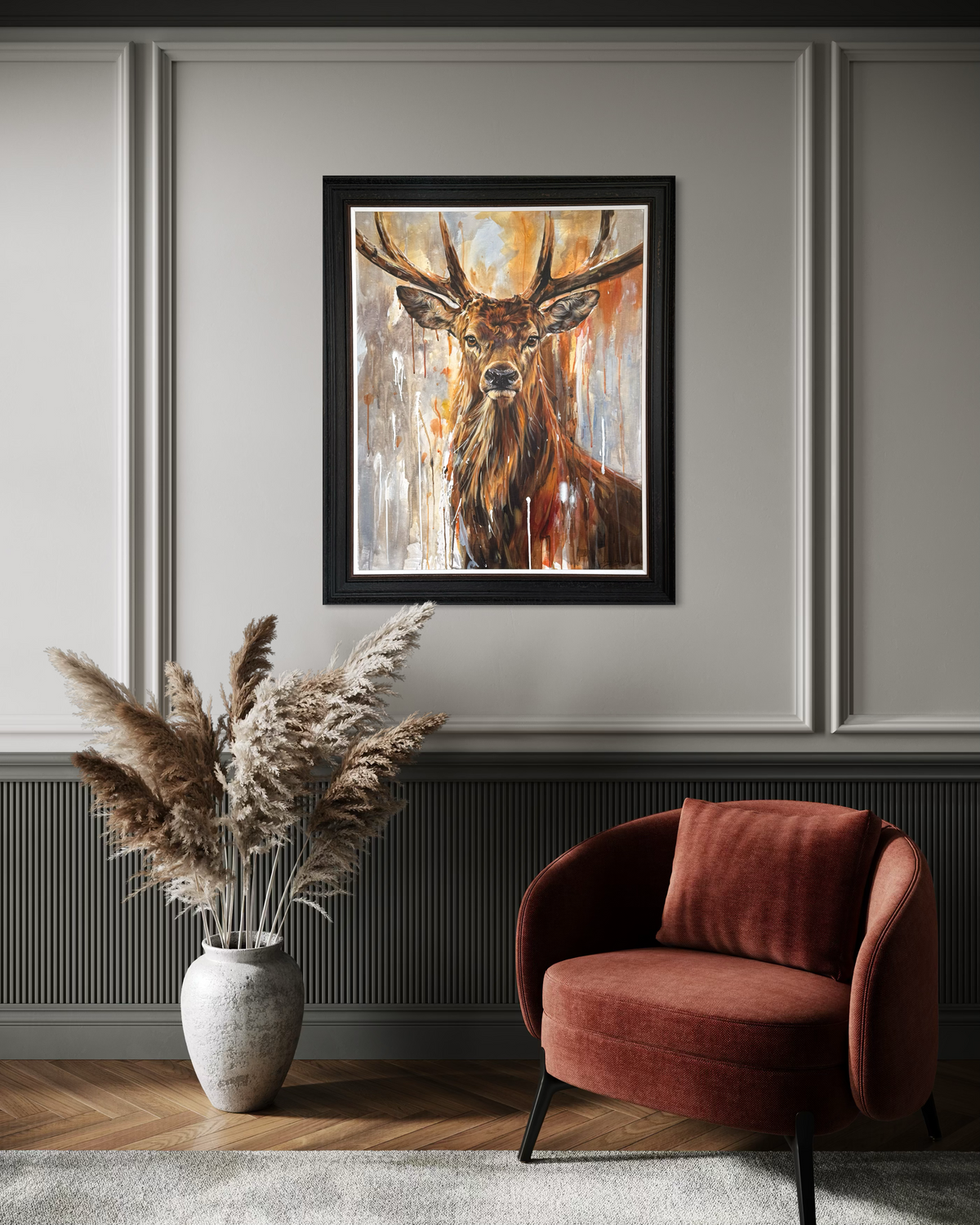 Framed painting of a stag on a wall above a red armchair and vase with pampas grass.