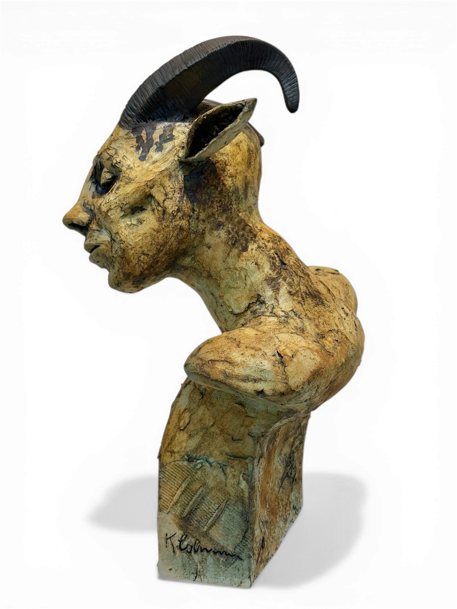 ceramic sculpture of a goat with large horns on a white background