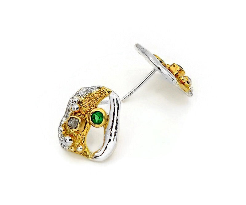 Gold and silver earring with green gemstone on a white background