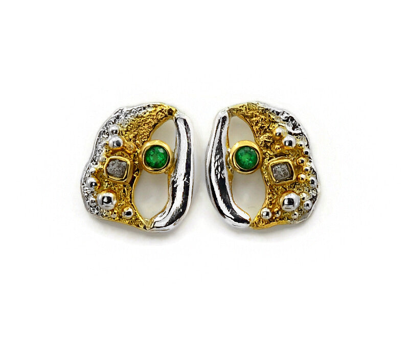 Pair of gold and silver earrings with green gemstones on a white background