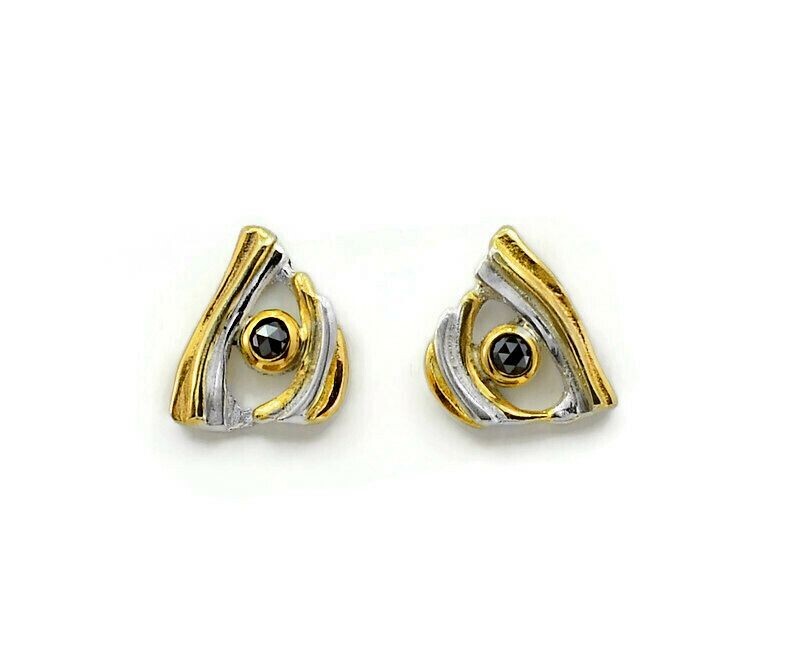 Pair of gold and silver triangle-shaped earrings with black gemstones on a white background