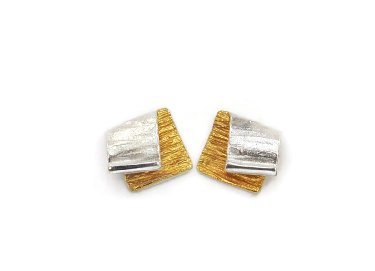 Pair of gold and silver earrings on a white background
