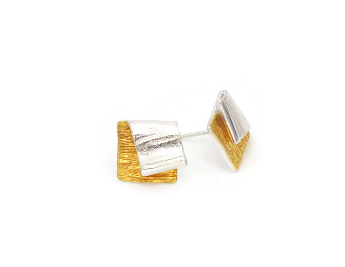 Pair of gold and silver geometric earrings on a white background