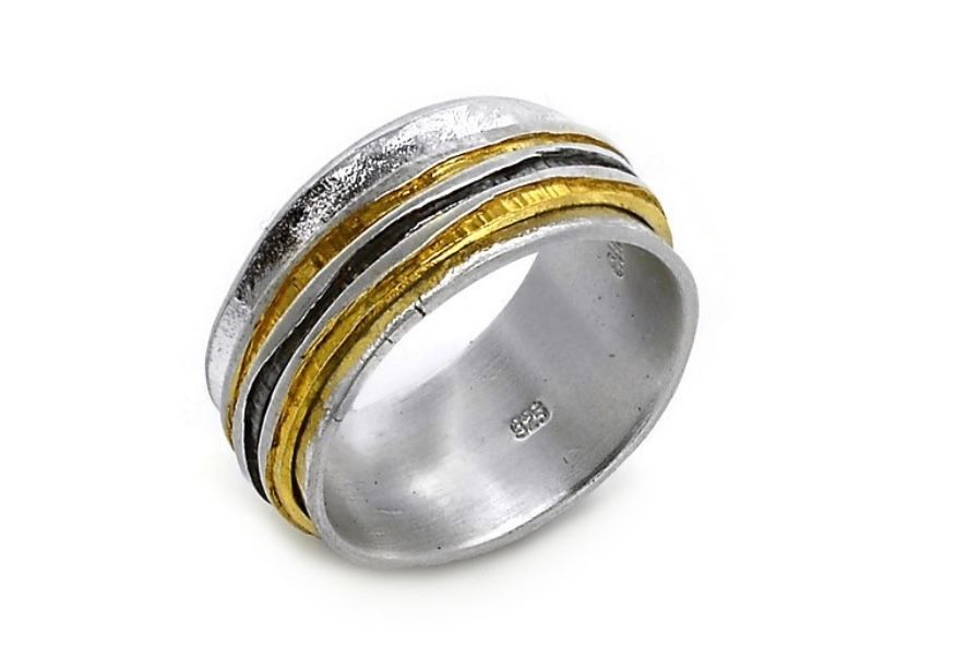 Silver ring with gold and black stripes on a white background