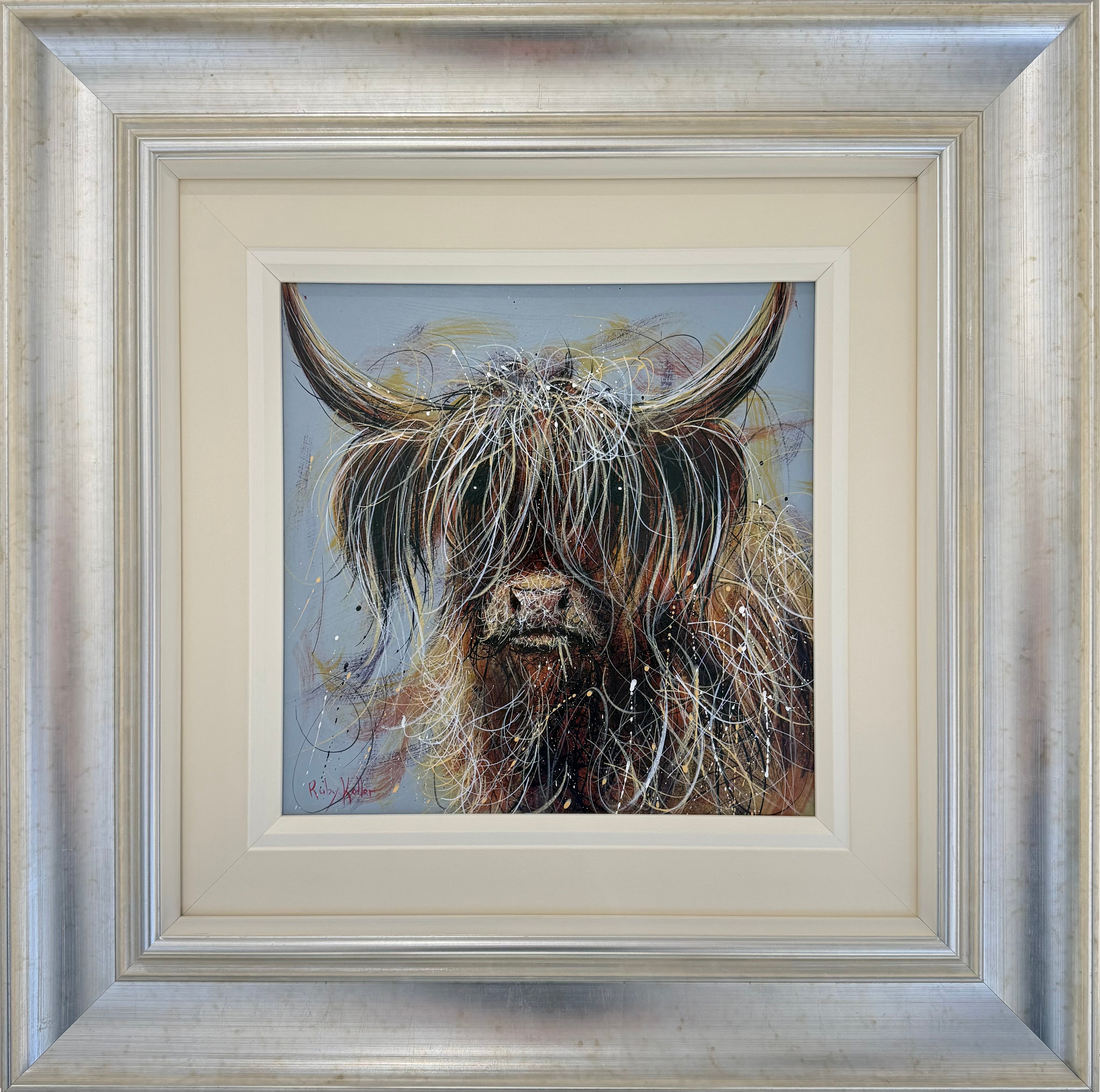 Framed painting of a Highland cow with long shaggy hair and curved horns, set in a silver frame with a cream mat.