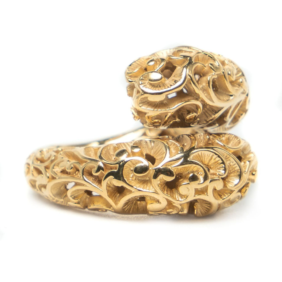 Gold ring with intricate design on a white background