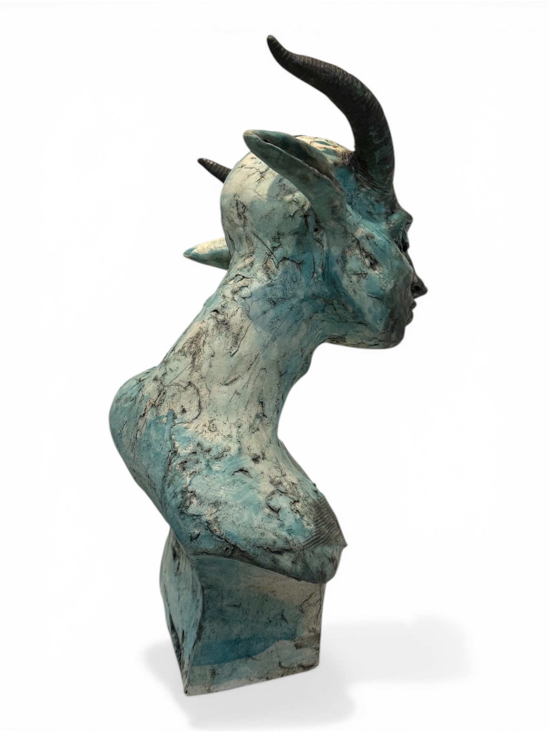 ceramic sculpture of a head with horns on a white background