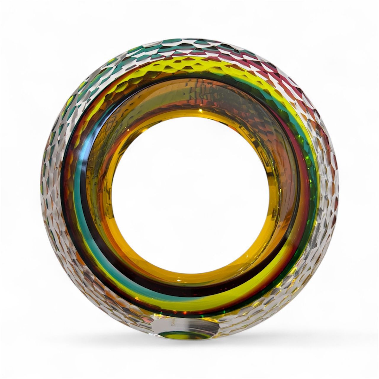 Multicolored glass object with concentric circular design on a white background