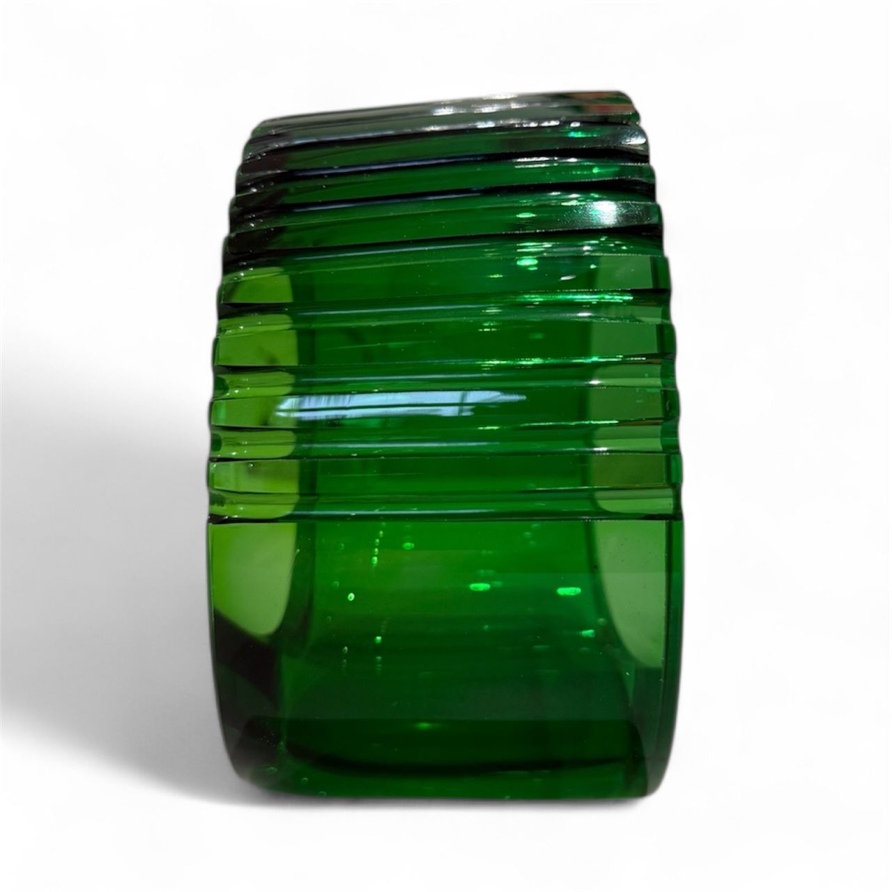 Green glass vase with ribbed design on a white background