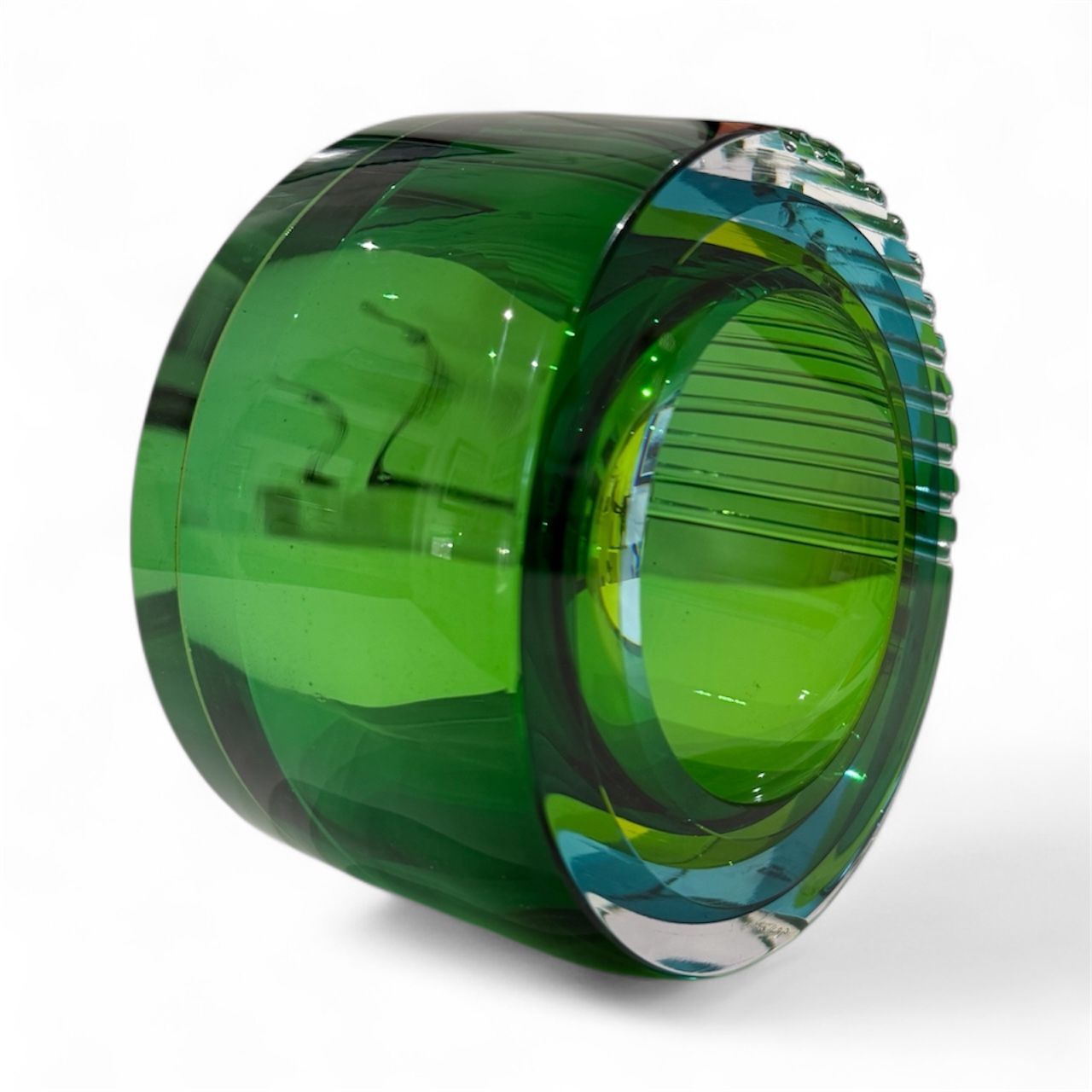 Green and blue translucent cylindrical object on a white background