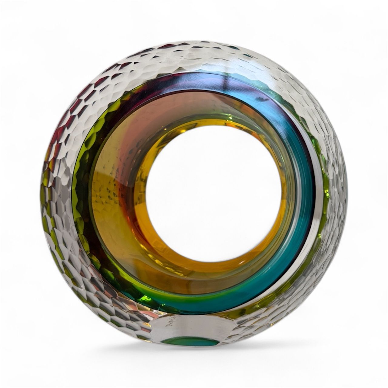 Multicolored glass object with textured surface on a white background