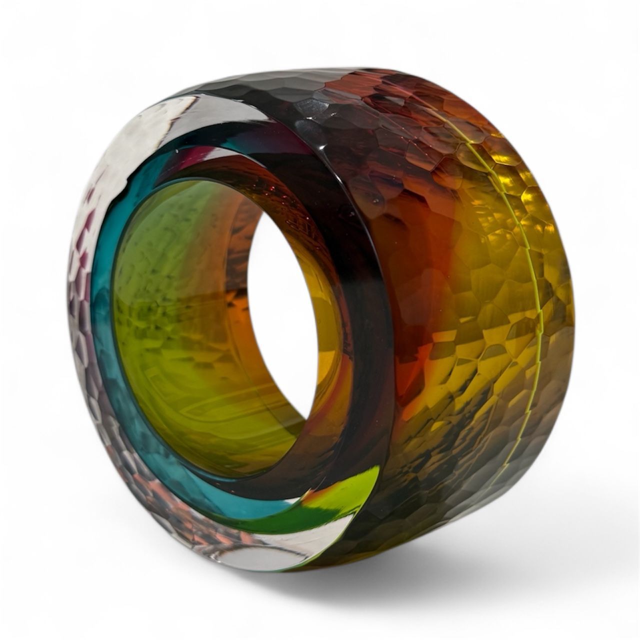Multicolored glass ring with a textured surface on a white background