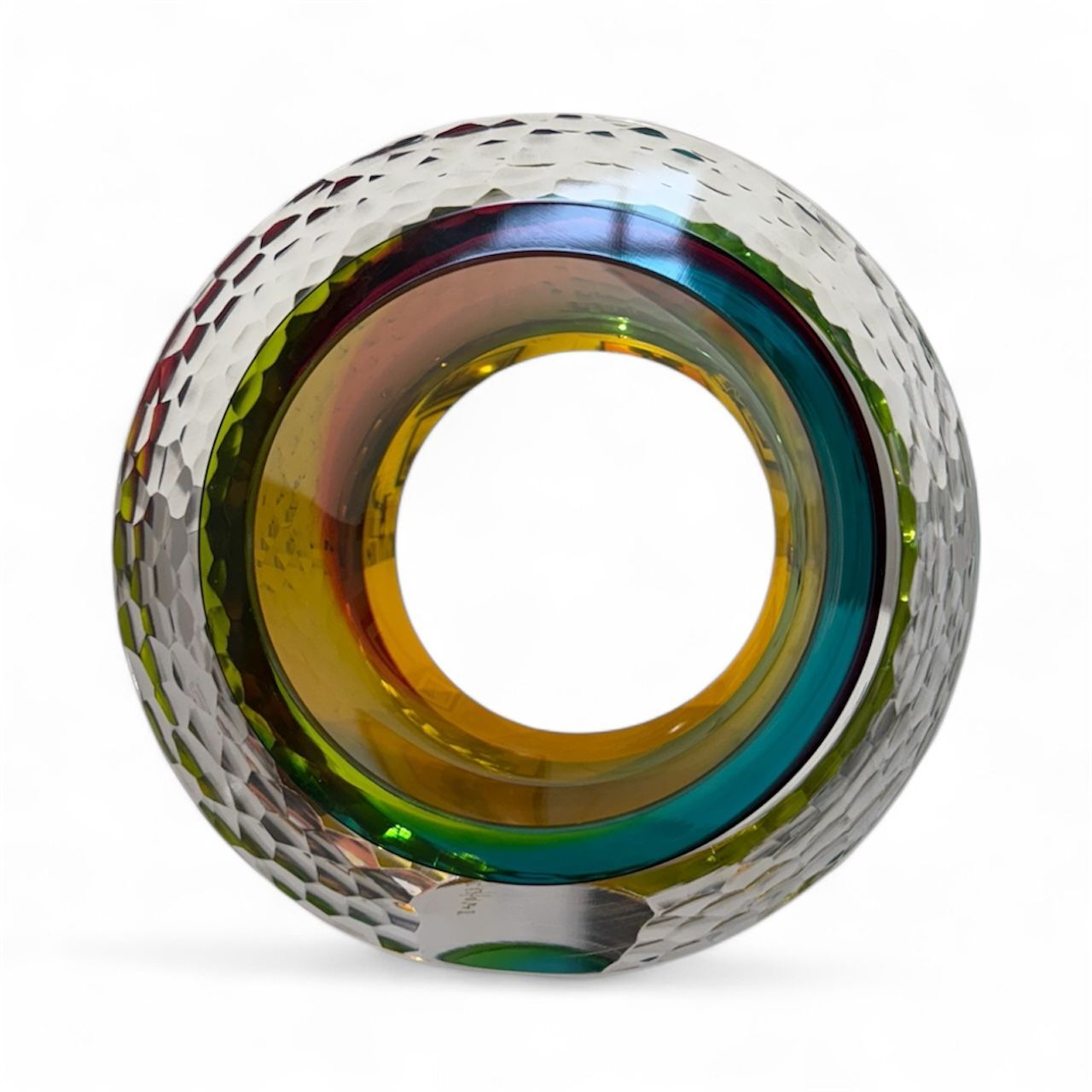 Multicolored glass object with a textured surface on a white background