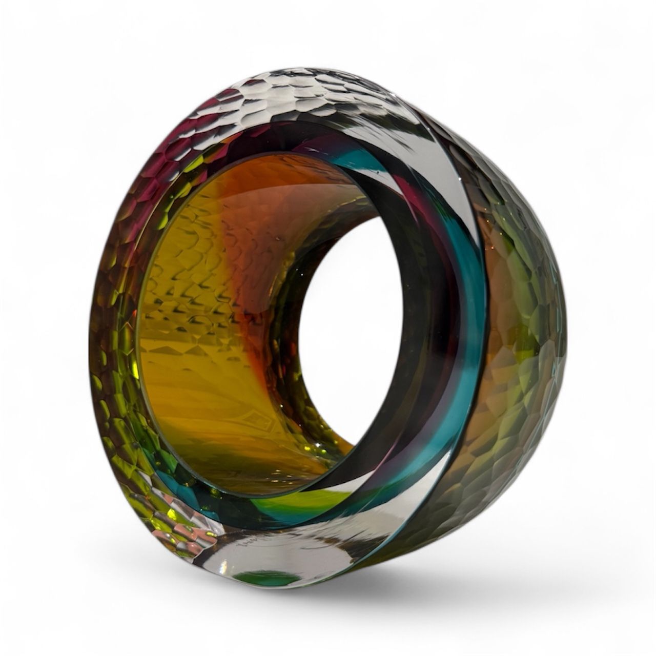 Multicolored glass ring with textured surface on a white background