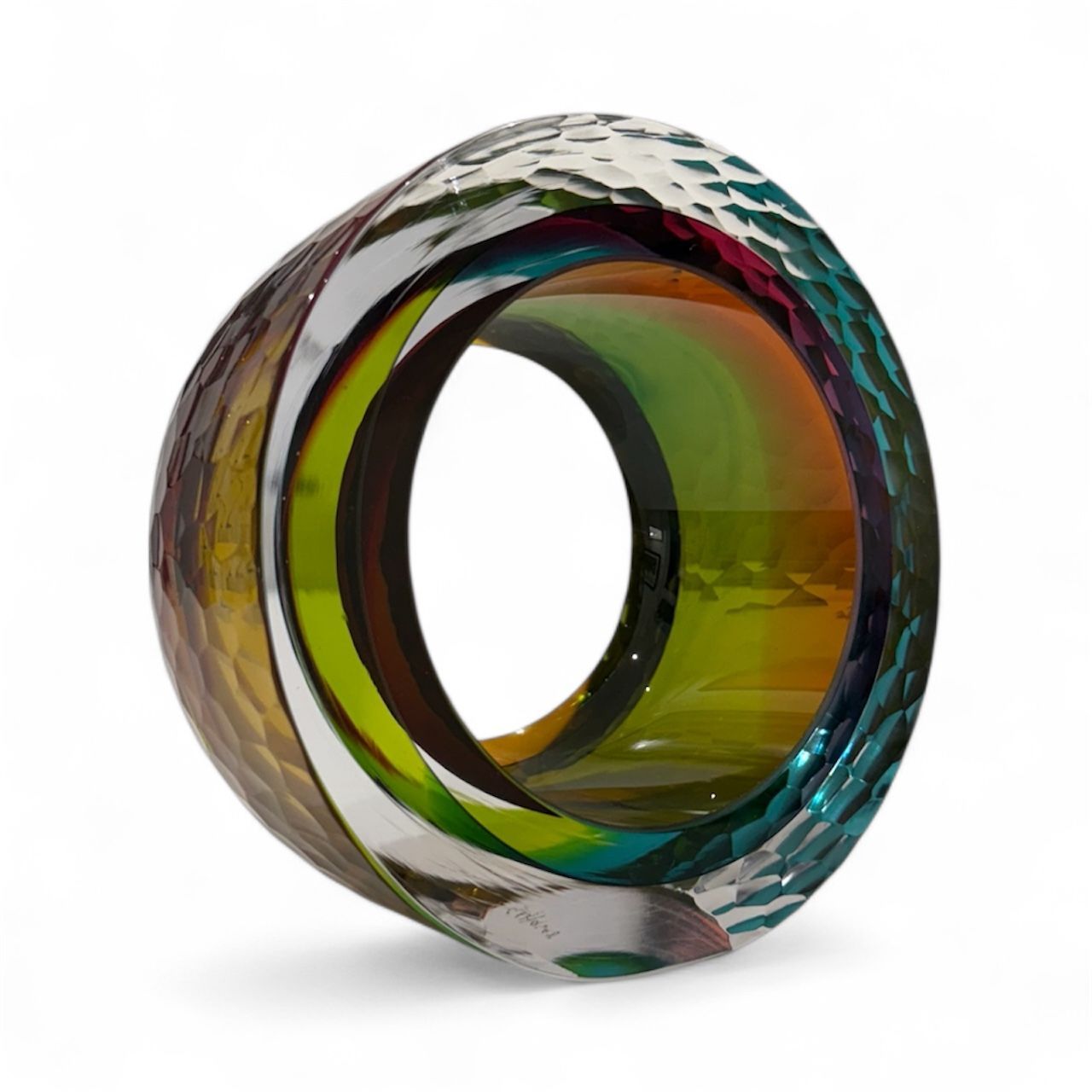 Multicolored glass ring with wavy pattern on a white background