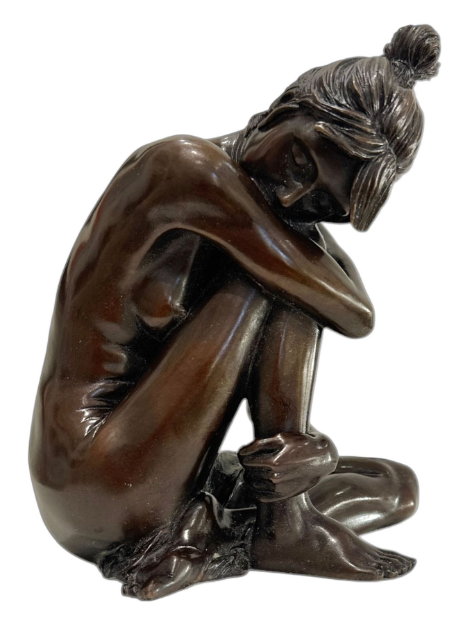 Bronze sculpture of a seated figure with a white background