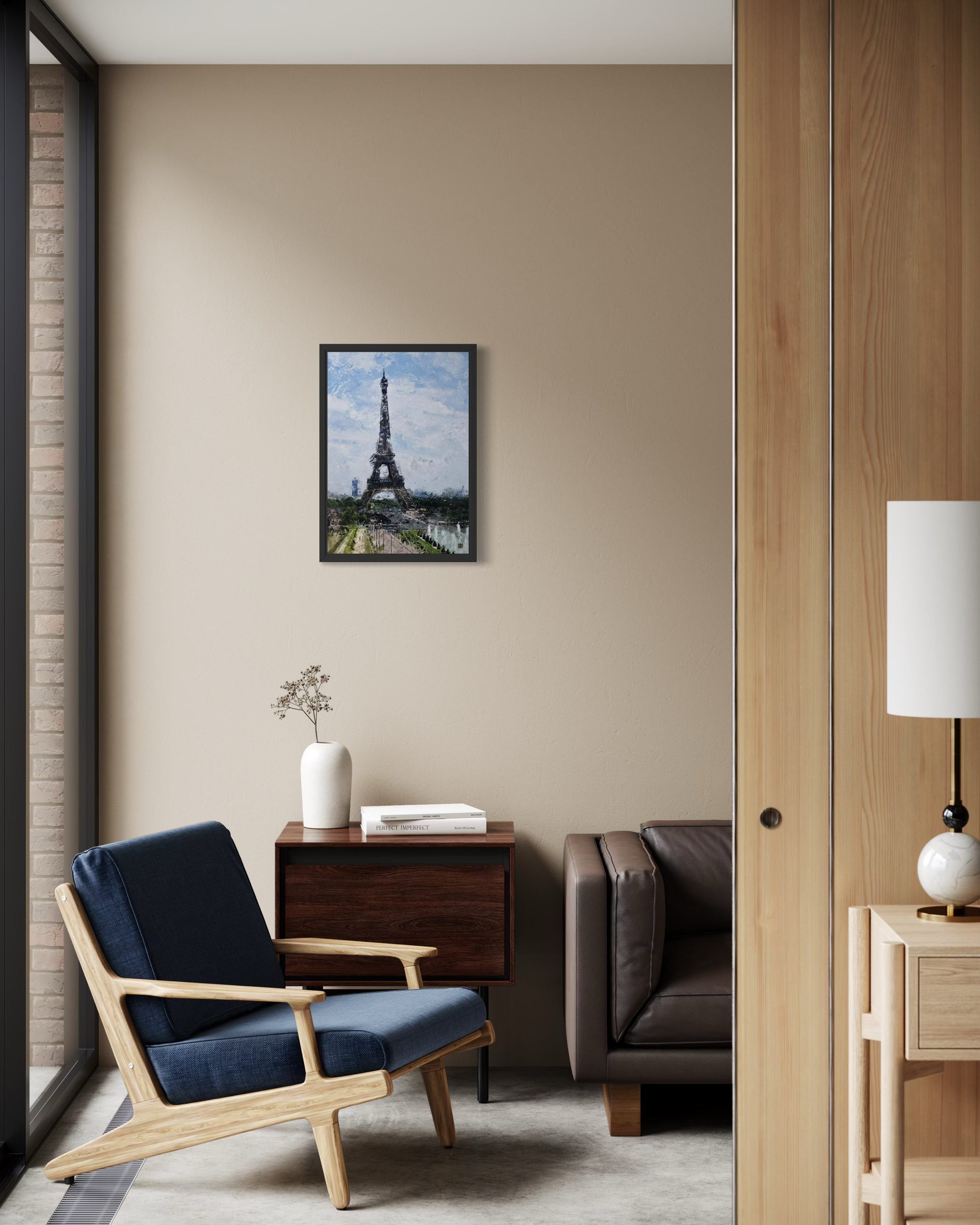 Modern living room with a blue armchair, wooden side table, and framed picture of the Eiffel Tower.