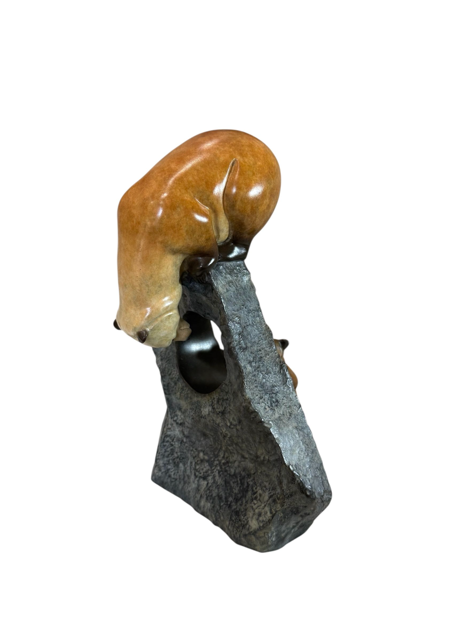 Sculpture of a bear climbing a rock on a white background
