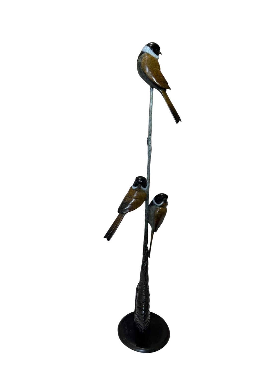 Decorative sculpture of three birds perched on a branch against a white background