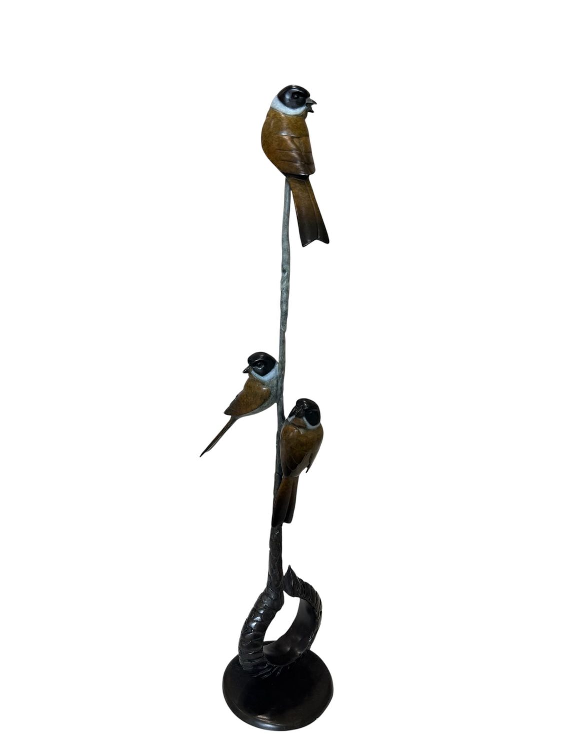 Decorative sculpture of three birds perched on a branch with a white background