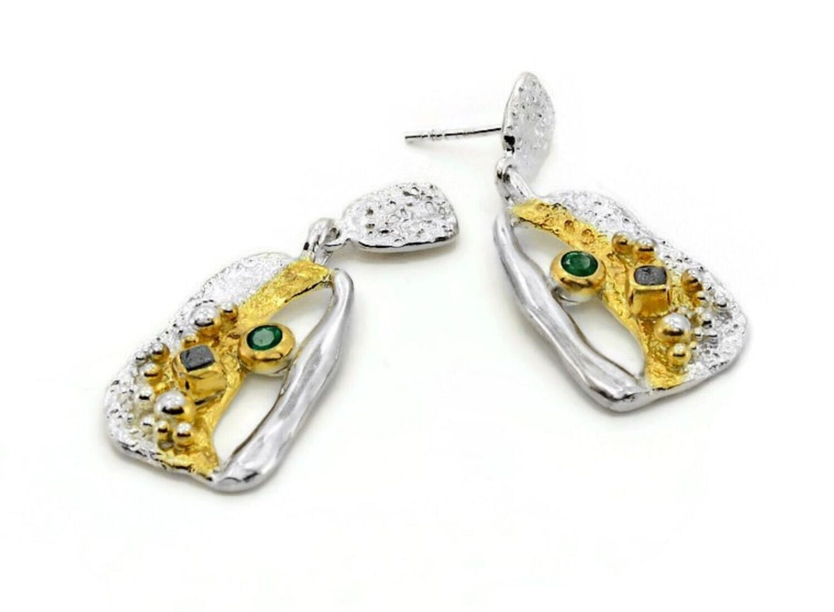 Pair of earrings with gold and silver design on a white background