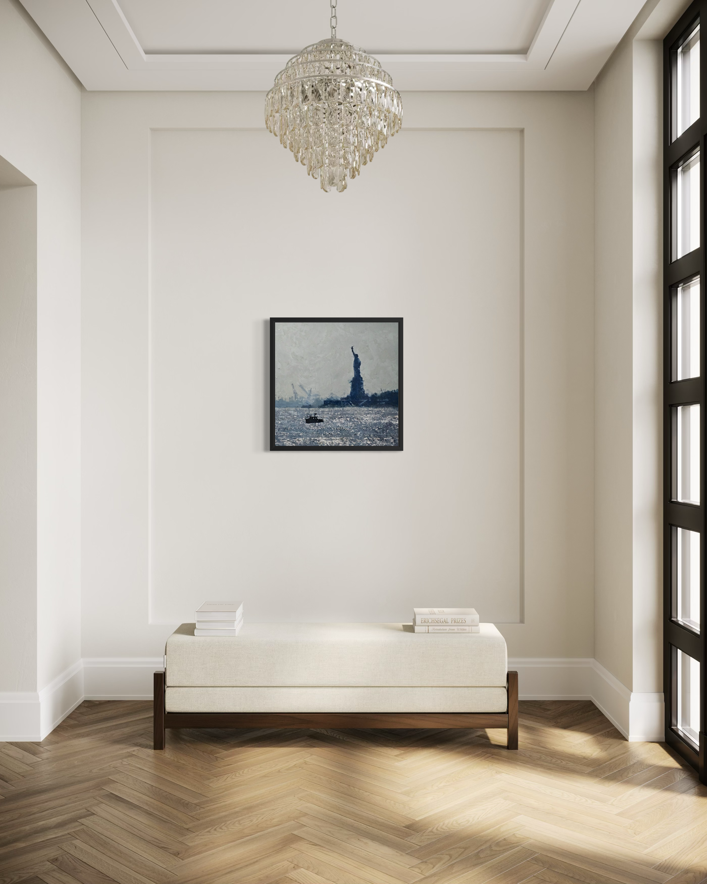 Modern interior with a chandelier, framed artwork of the Statue of Liberty by Ben Ark, and a white bench.