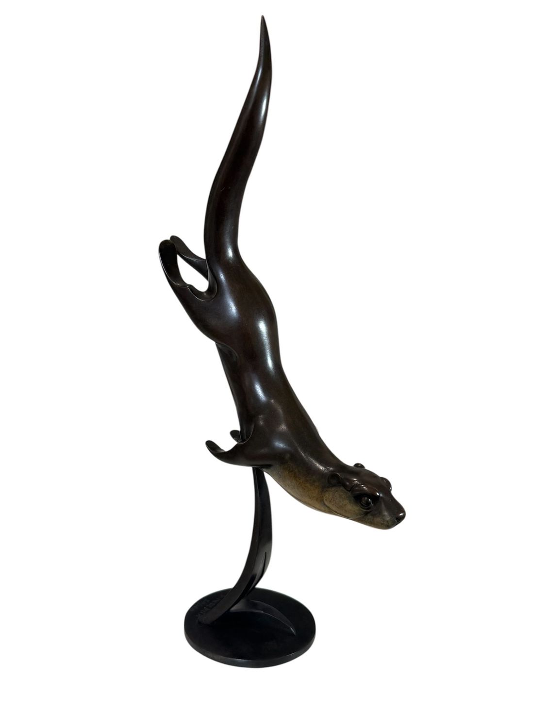 Bronze sculpture of a leaping otter on a white background