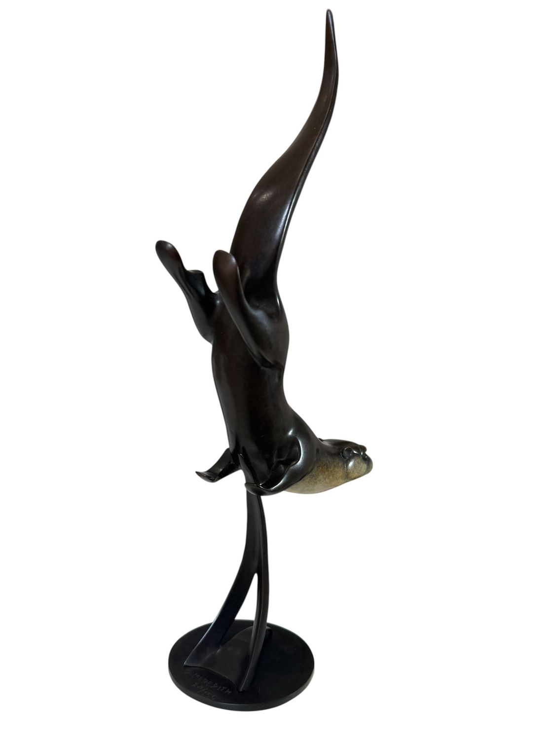 Bronze sculpture of a otter leaping out of water on a white background