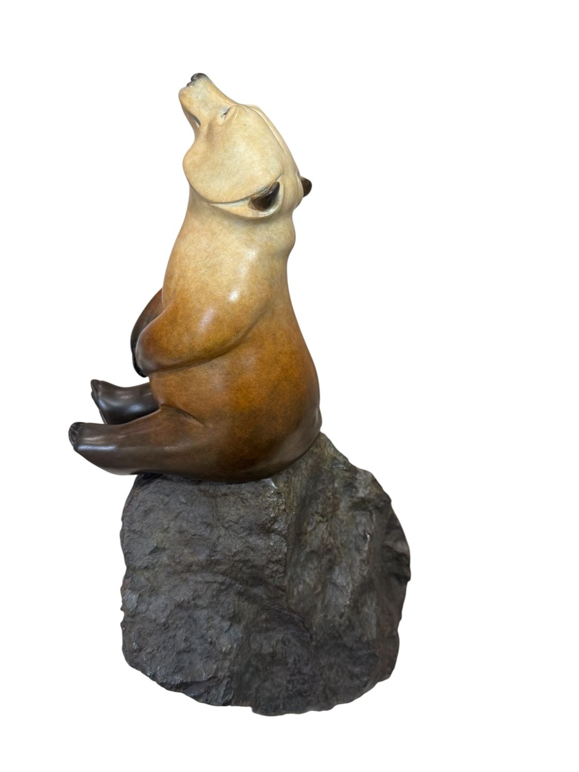 Bear sculpture on a rock with a white background