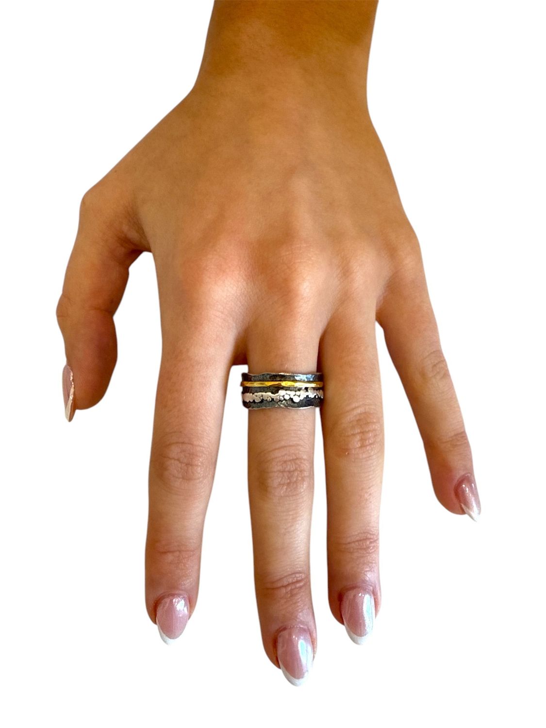 Hand wearing multiple rings on a white background