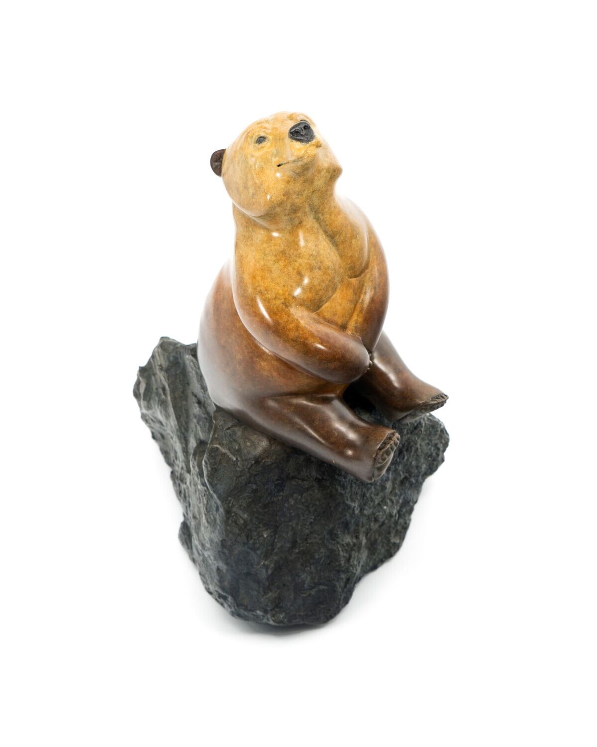 Stone sculpture of a bear on a rock with a white background