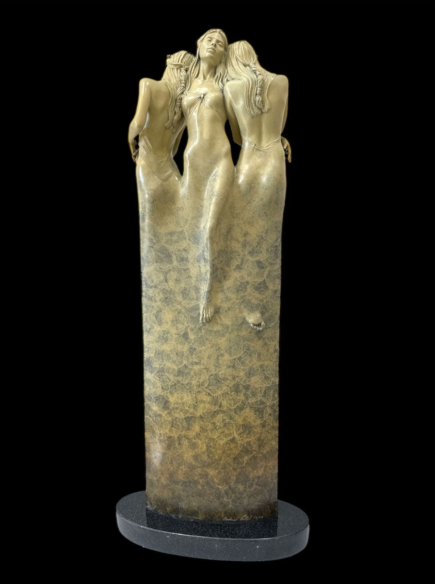 Statue of three nude figures on a pedestal against a black background