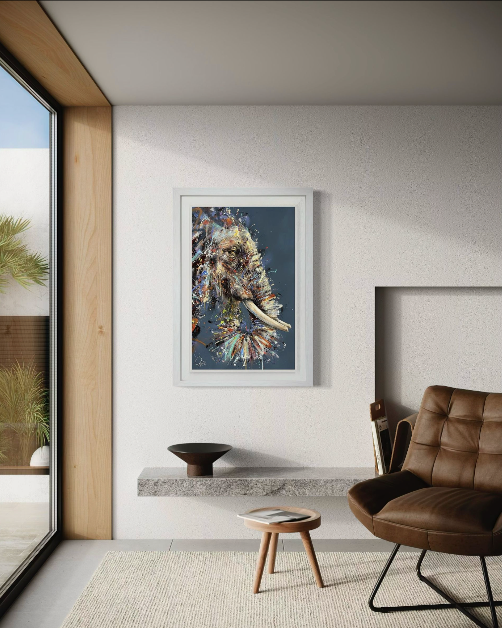 Modern interior with a framed joe galindo on the wall, brown chair, and small table.