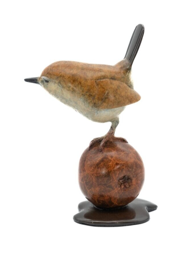 Statue of a bird perched on a spherical object with a white background