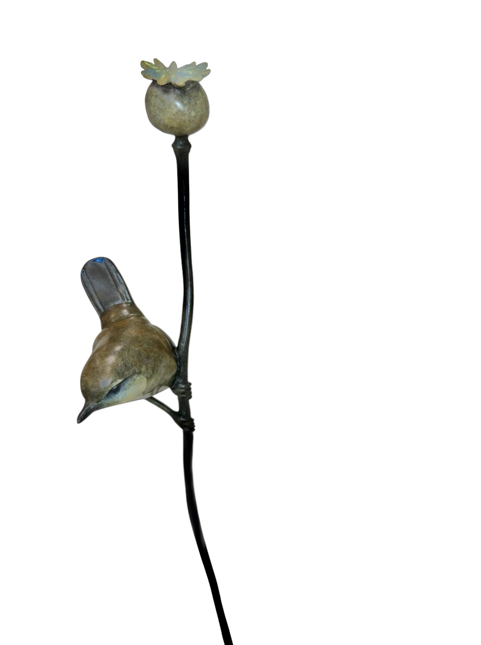 Decorative wren sculpture perched on a branch with a white background