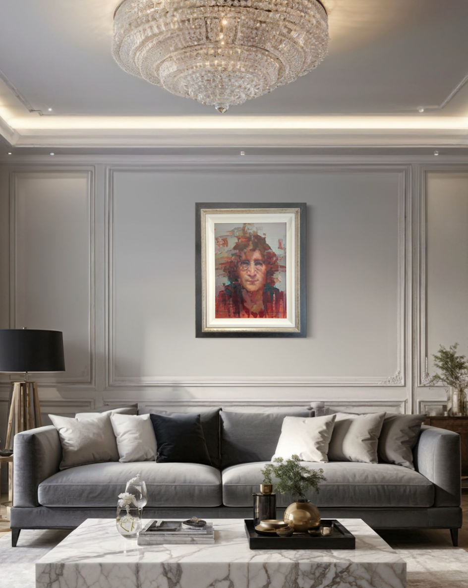 Modern living room with gray sofa, marble coffee table, and framed artwork of john lennon on the wall.